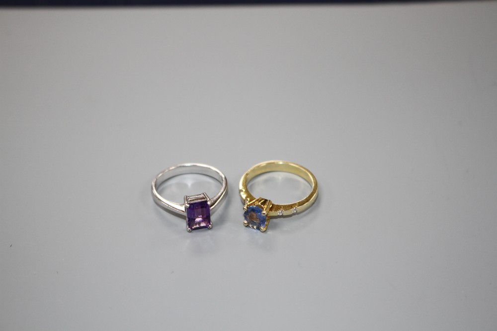 A yellow metal and single stone oval cut Ceylon? sapphire ring with diamond set shoulders and a 750 amethyst ring.